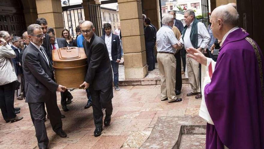 El párroco Ángel Rodríguez Viejo recibiendo el féretro, ayer, en la iglesia de San Tirso el Real.