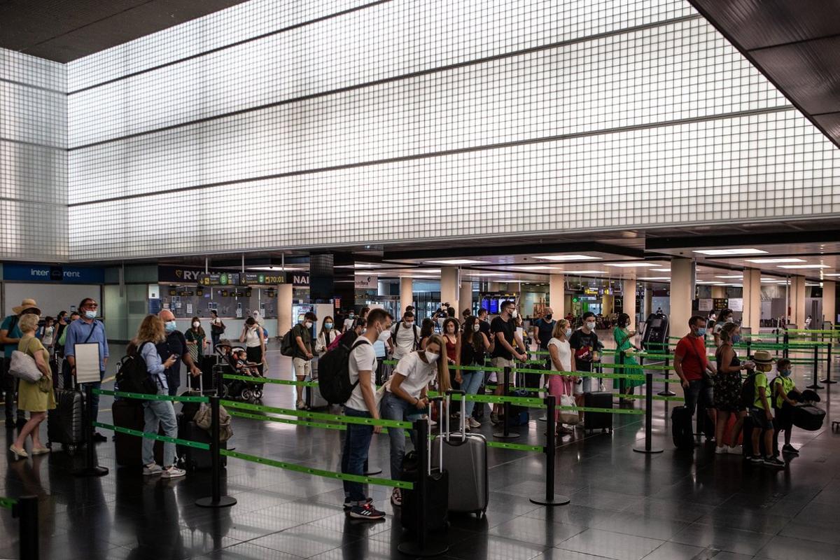 GRAFCAT127. BARCELONA, 24/07/2020.- Varios pasajeros en los mostradores de facturación de la T2 del Aeropuerto de El Prat que se ha puesto nuevamente en servicio este viernes para adaptarse a la situación operativa, facilitar la distancia de seguridad y evitar posibles aglomeraciones en las instalaciones. EFE/Enric Fontcuberta