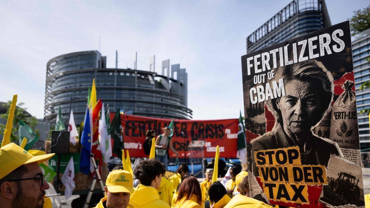 Protesta de agricultores comunitarios sostienen pancartas para denunciar la crisis de fertilizantes frente a la sede del Parlamento Europeo en Estrasburgo.
