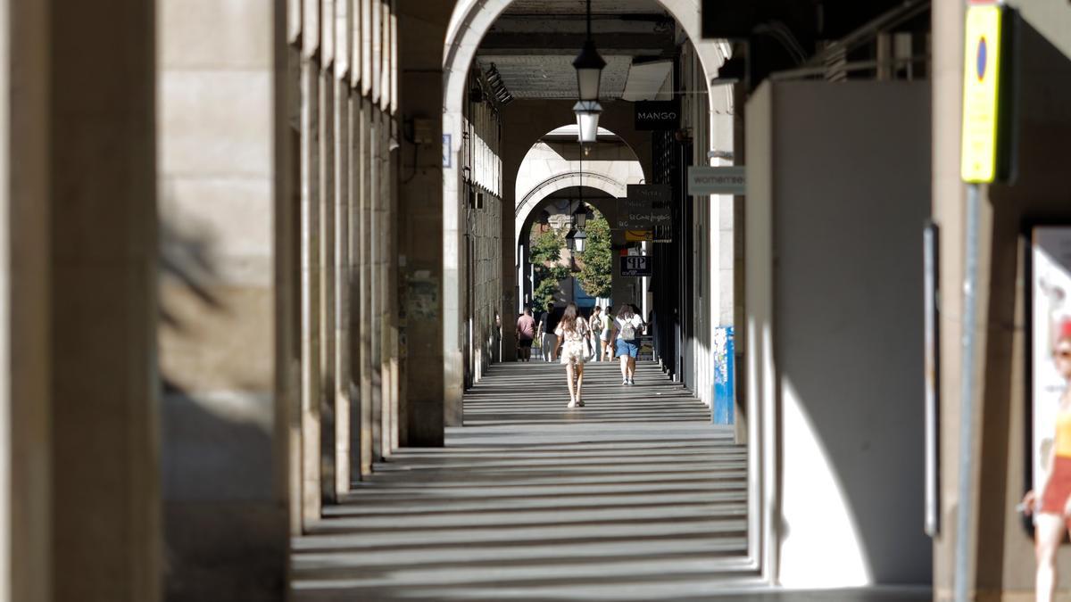 Paseantes en los porches del paseo de la Independencia de Zaragoza.