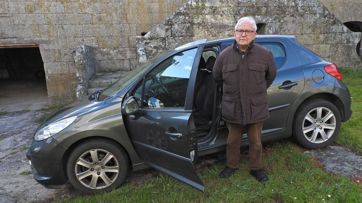 El sacerdote Fernando Rodríguez, en la rectoral de Atás, junto a su coche.