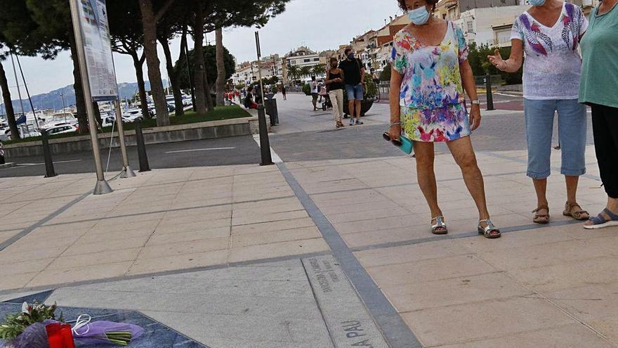 Tres dones observant el memorial commemoratiu.