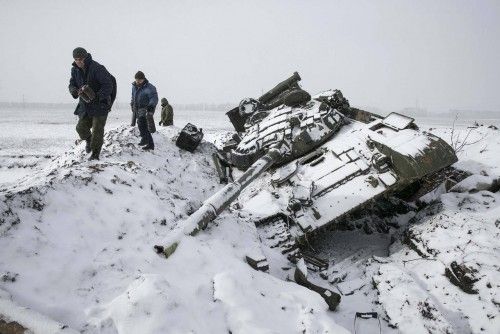 Miembros del ejército separatista recuperan partes de un tanque destruido en Ucrania