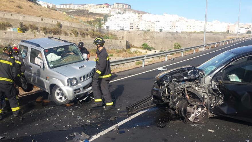 Los bomberos, entre los dos vehículos implicados en el choque, durante las tareas de extracción de los ocupantes.