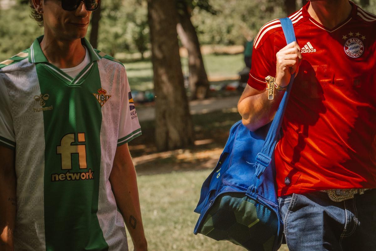 Roberto, con su camiseta del Betis, y Pablo, con la del Bayern de Múnich, caminan por el Retiro. 