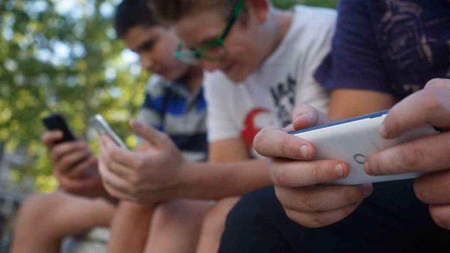 Tres jóvenes zamoranos concentrados en sus teléfonos móviles. Foto