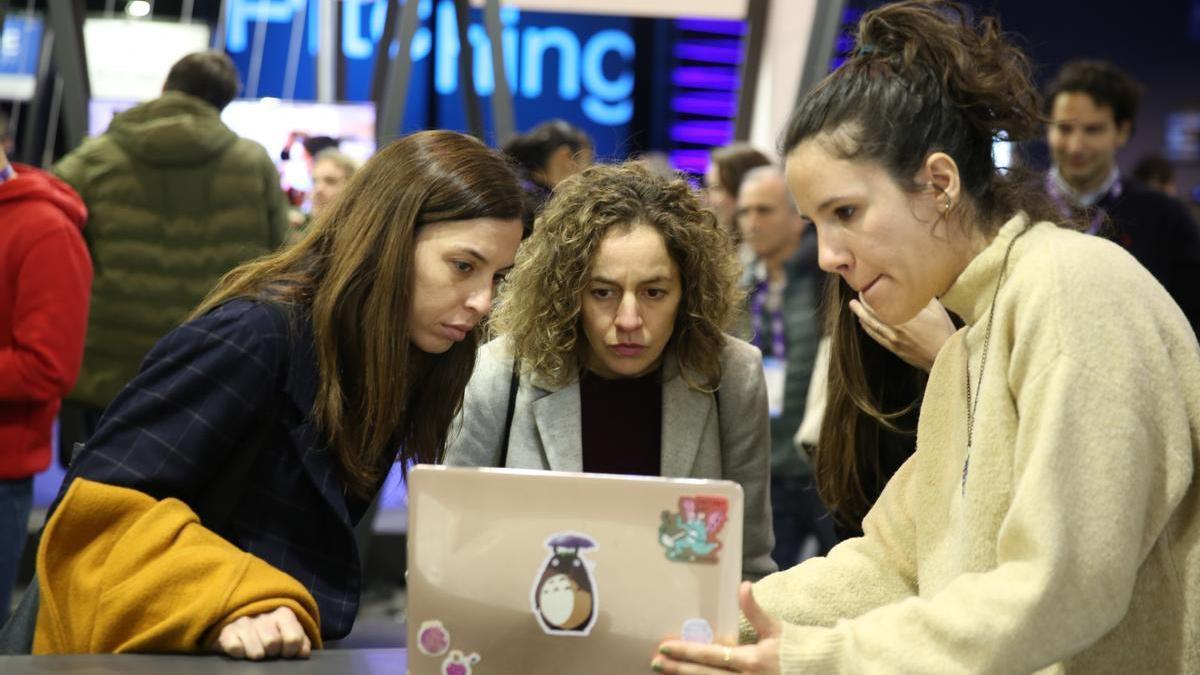 Tres participantes del 4YFN, el salón de las ’startups’ del Mobile World Congress, interactúan con una aplicación en el congreso de este año.