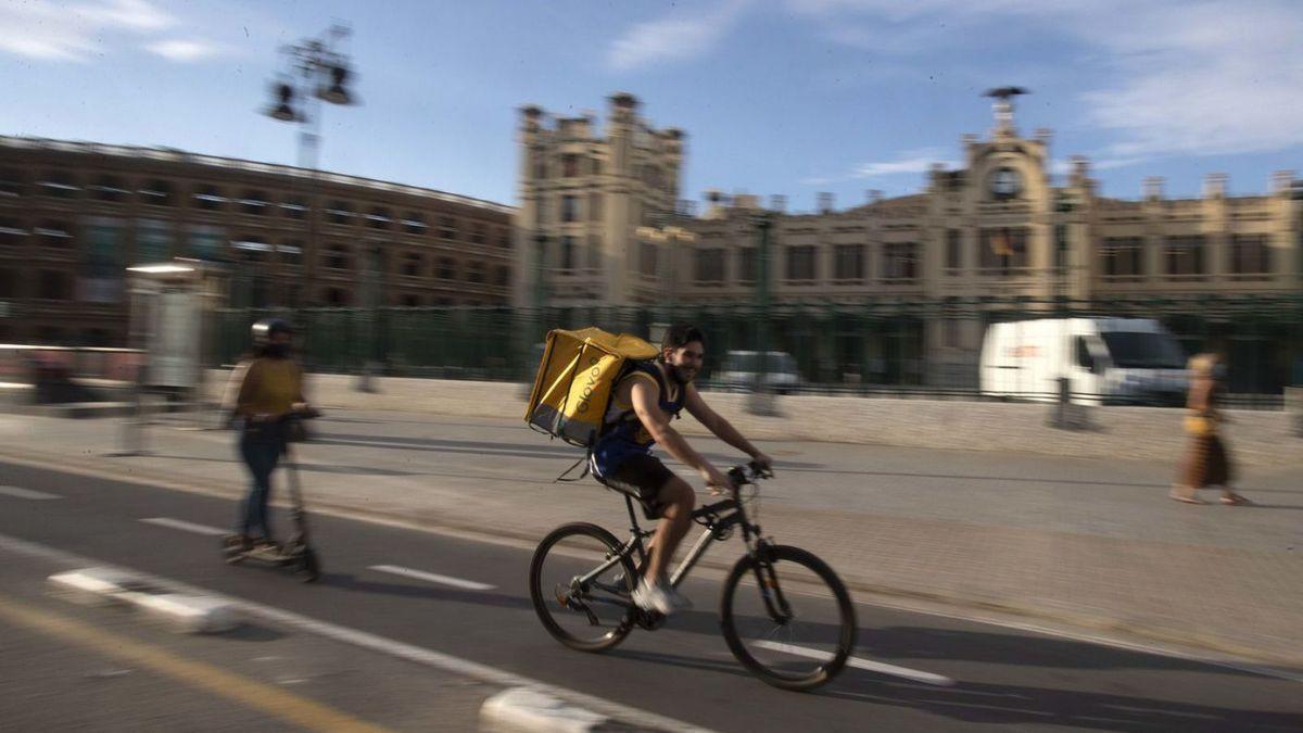 Un rider de Glovo entrega un pedido en la estación del norte de Valencia.