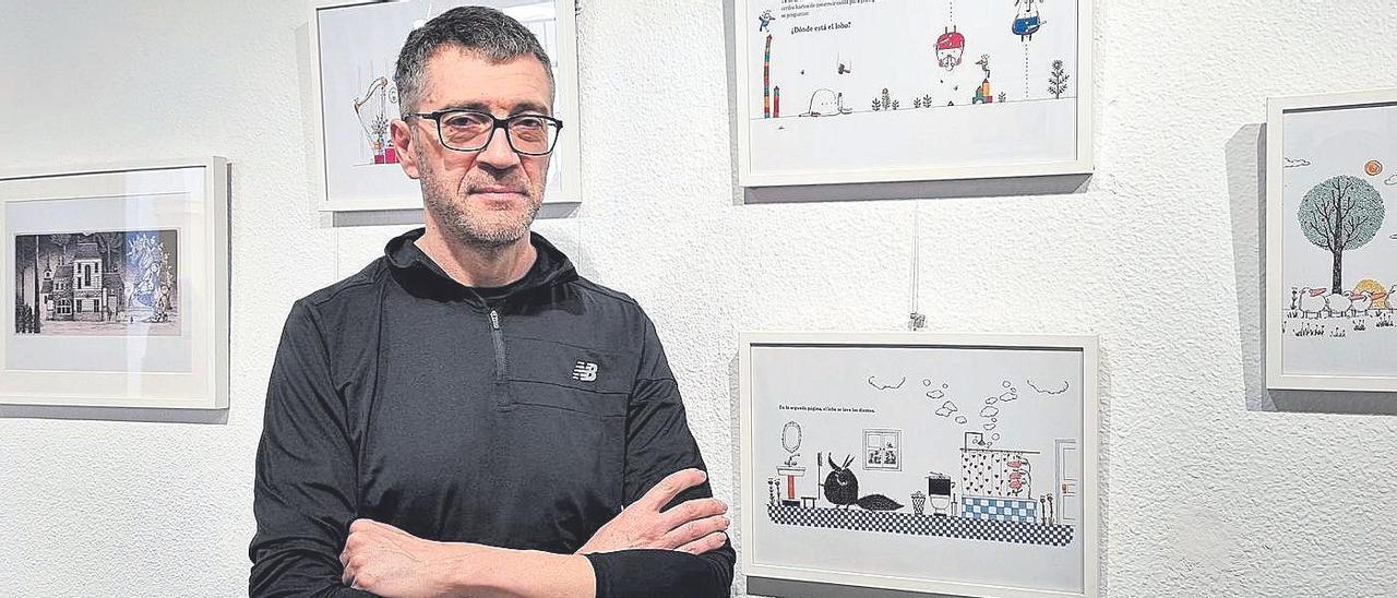 El dibujante Enrique Quevedo, junto a la exposición que tiene en la Escuela de Arte ‘Dionisio Ortiz’.