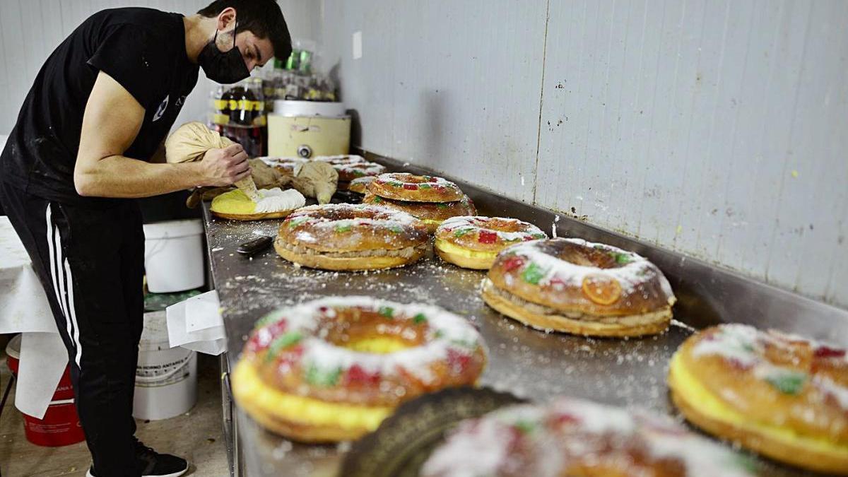 Un repostero rellena los roscones en el horno de la confitería Pani.