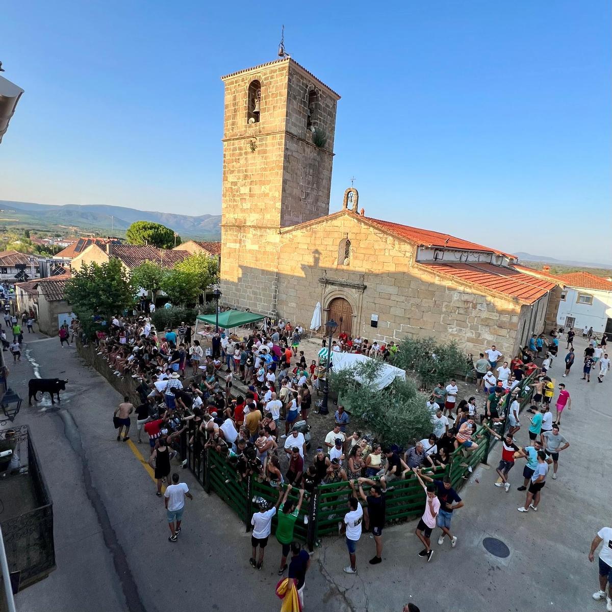 Numerosos vecinos llenan el entorno de la iglesia durante uno de los festejos taurinos de la localidad.