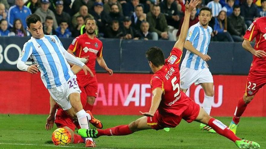 Juanpi se marcha de dos defensores del Getafe antes de lograr el 1-0.