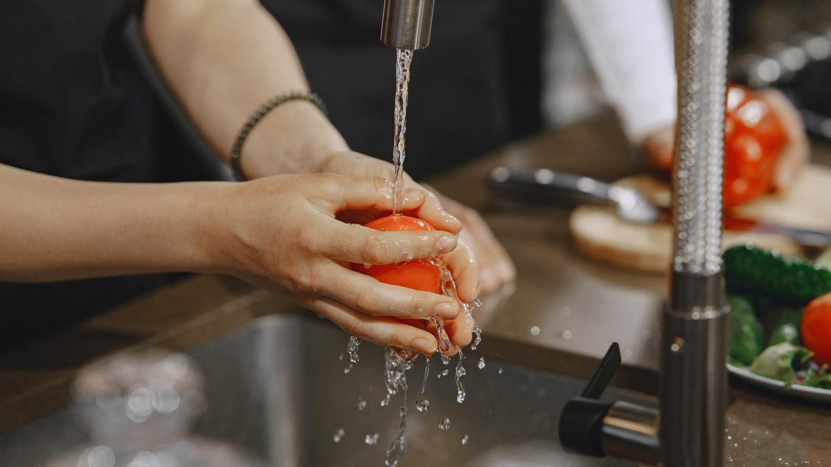 Una persona limpia fruta con agua