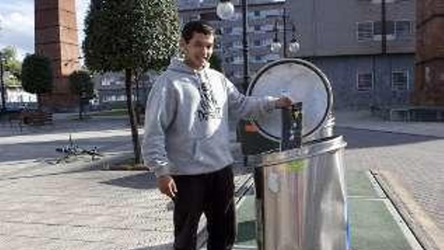 Un joven utiliza uno de los contenedores de reciclaje de La Felguera.