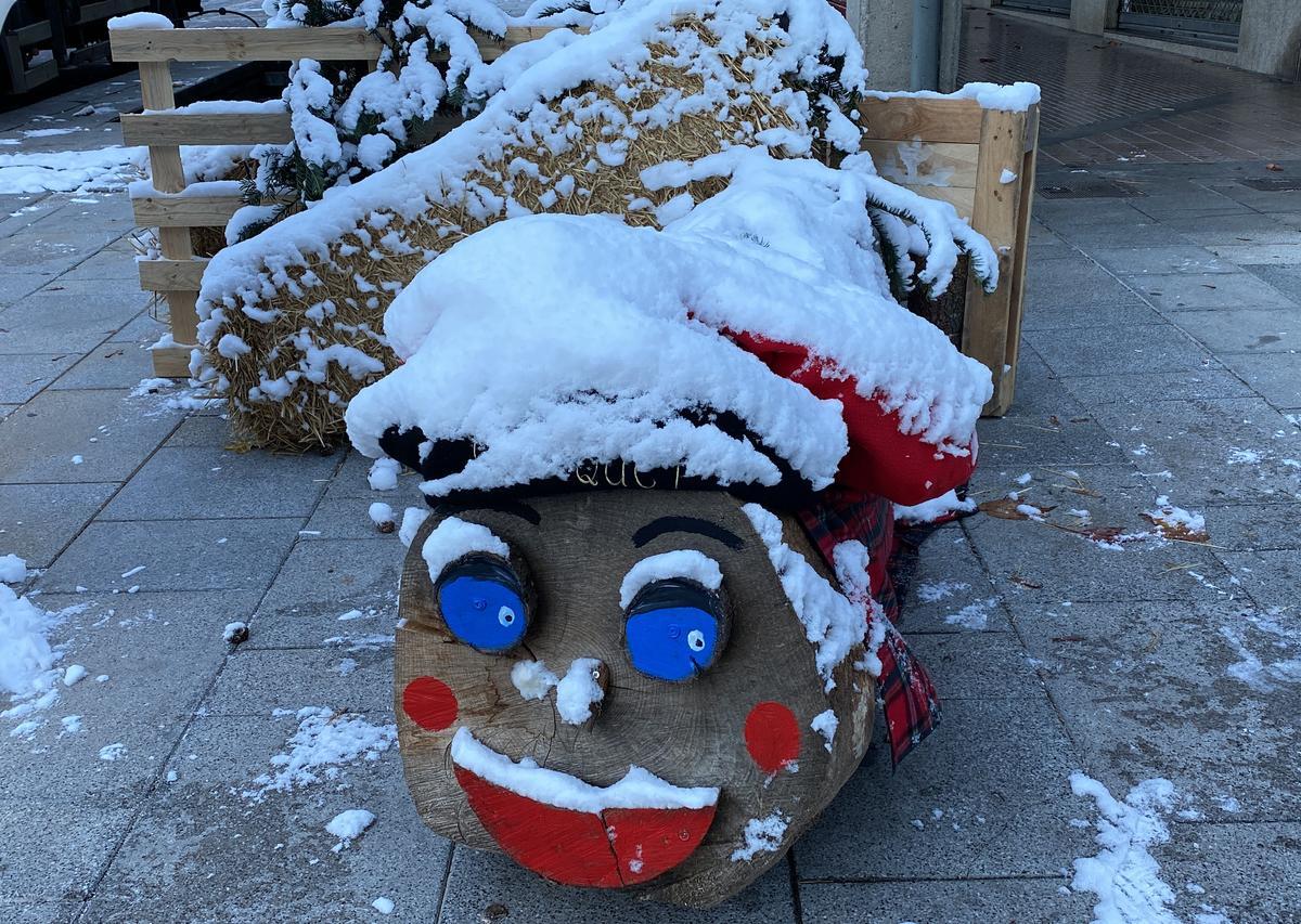 Un ’tió’ navideño cubierto de nieve en una de las calles del centro de La Seu d’Urgell.