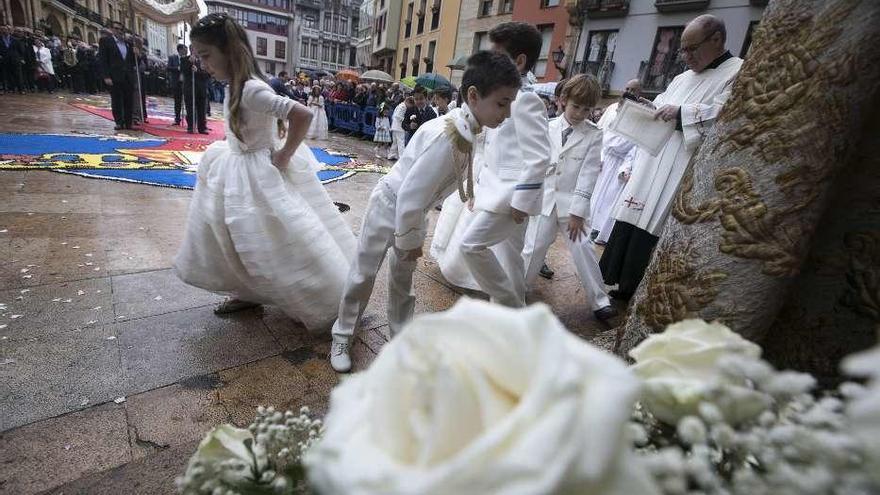 A la izquierda, niños que este año hicieron la primera comunión, en la procesión del Corpus junto a la Catedral. A la derecha, concejales del PP durante la misa.