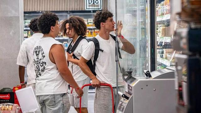 Turistes joves assortint-se en un supermercat al barri de la Mina, a Sant Adrià de Besòs. | MANU MITRU
