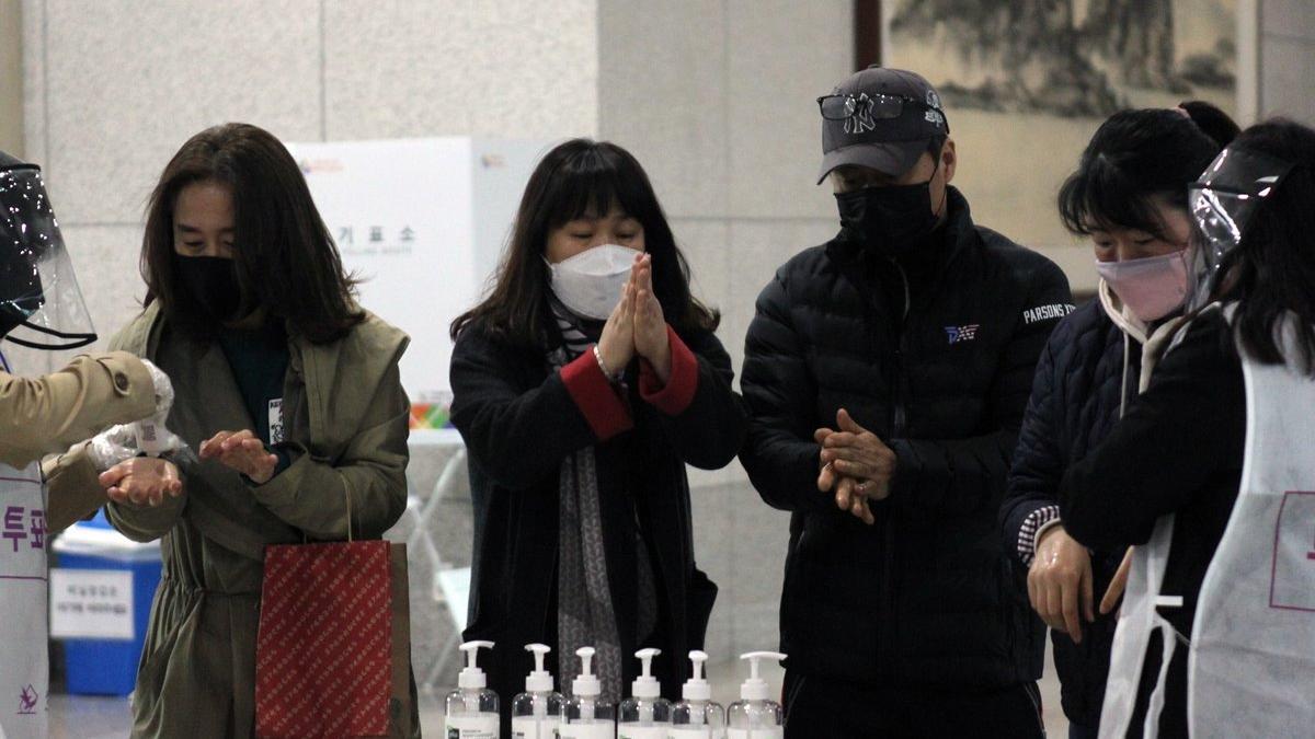 Ciudadanos se desinfectan las manos antes de votar en las elecciones que se celebran en Corea del Sur.