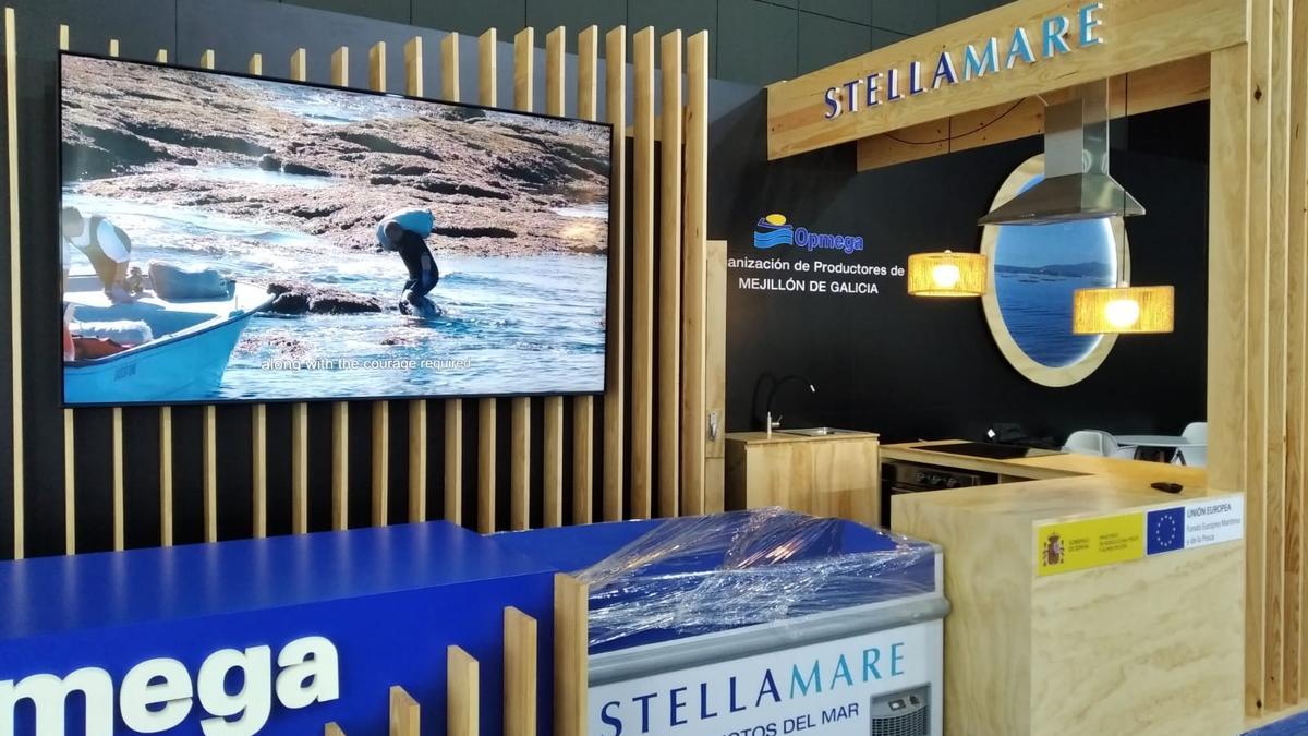 El puesto de exposición montado por Opmega en Seafood Barcelona, donde muestra el proceso de recolección de la mejilla, como se aprecia en la pantalla.