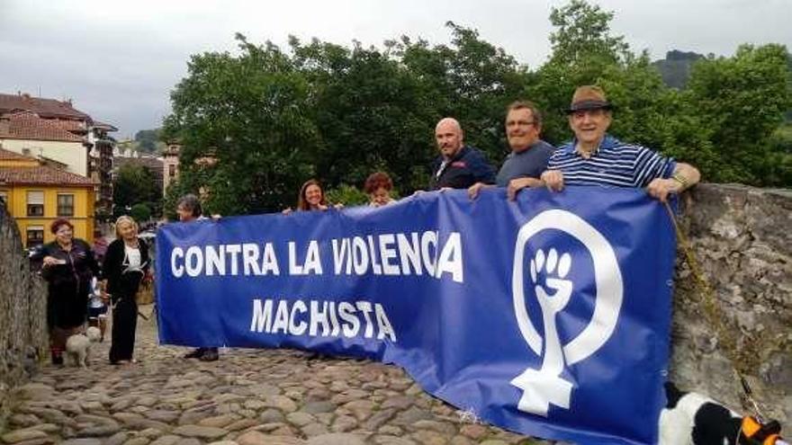 Participantes en la concentración contra la violencia machista en el puente &quot;romano&quot; de Cangas de Onís, ayer.