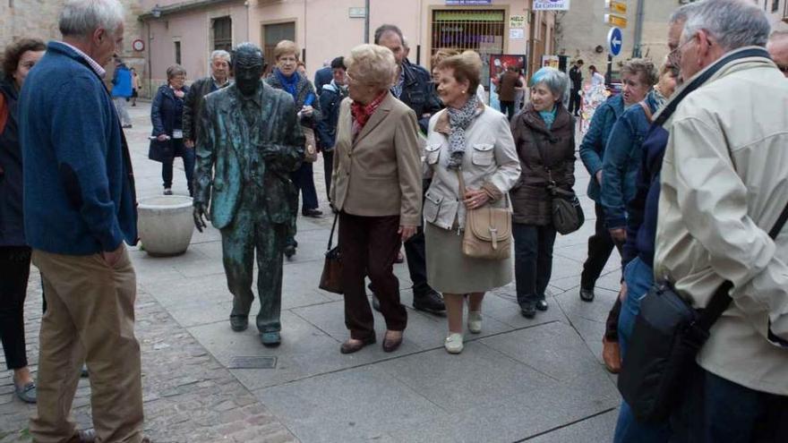 Un grupo de turistas observa curioso la estatua de Herminio Ramos.