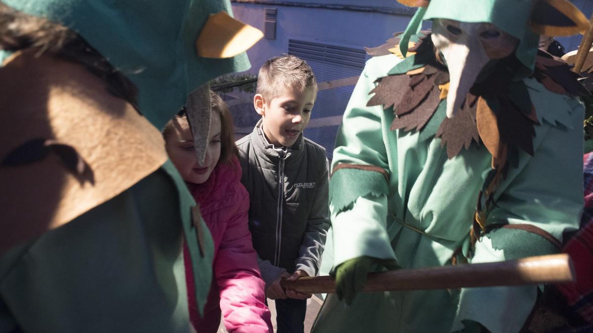 Dos 'tioners' ajudant els infants a fer cagar el tió en una edició anterior