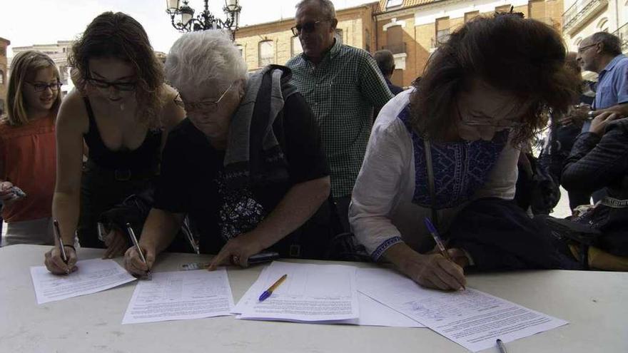 Tres mujeres estampan su firma en las hojas para reclamar a la Junta un pediatra 24 horas