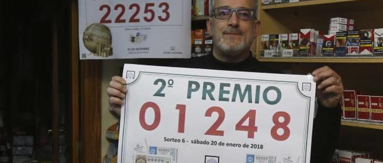 El titular del estanco, Jesús Boil, ayer, muestra un cartel con el número premiado.