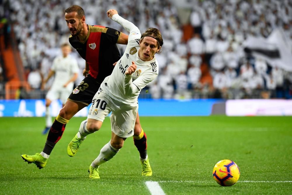 Rayo Vallecano's Spanish defender Alex Galvez (L) vies with Real Madrid's Croatian midfielder Luka Modric during the Spanish League football match between Real Madrid and Rayo Vallecano at the Santiago Bernabeu stadium in Madrid on December 15, 2018. (Photo by GABRIEL BOUYS / AFP)