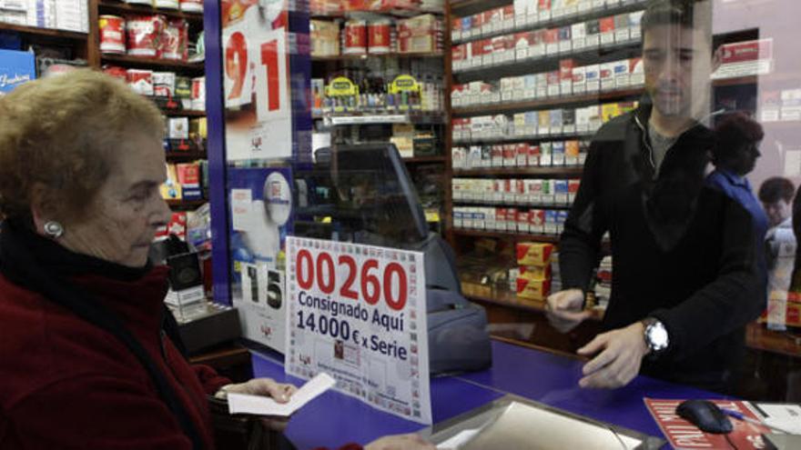 Una mujer compra lotería en una administración.