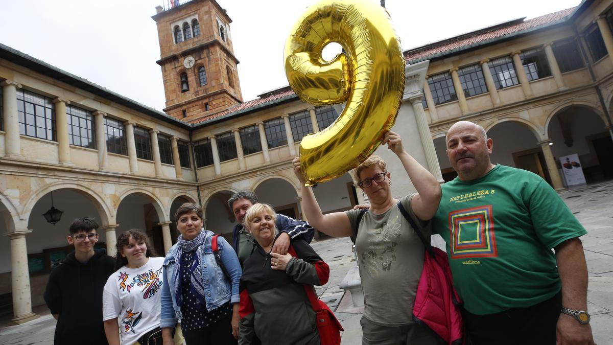 La familia Gutiérrez, de Zaragoza, posa en el patio de la Universidad con la nota media que los turistas encuestados por LA NUEVA ESPAÑA otorgaron a la región: un 9.