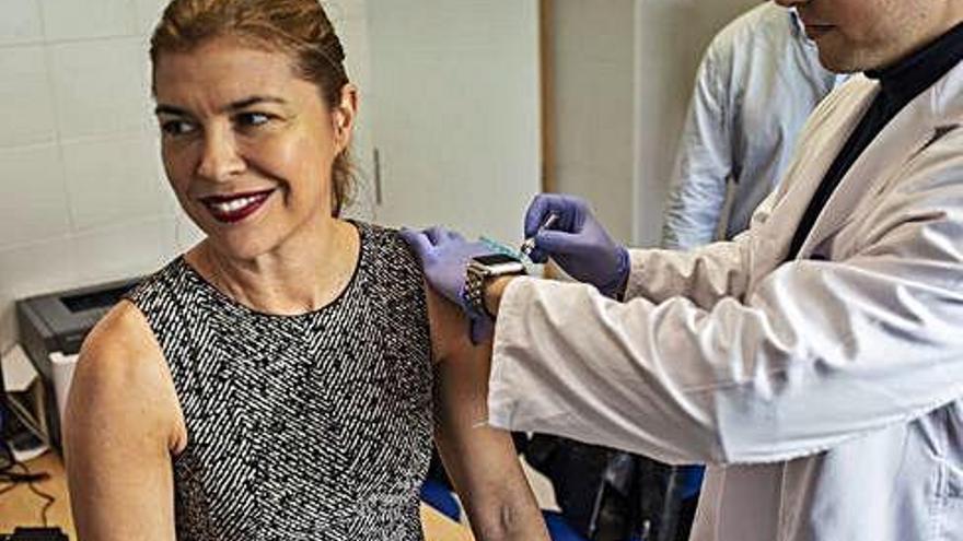 La delegada de la Junta, Clara San Damián, se pone la vacuna contra la gripe en Puerta Nueva.