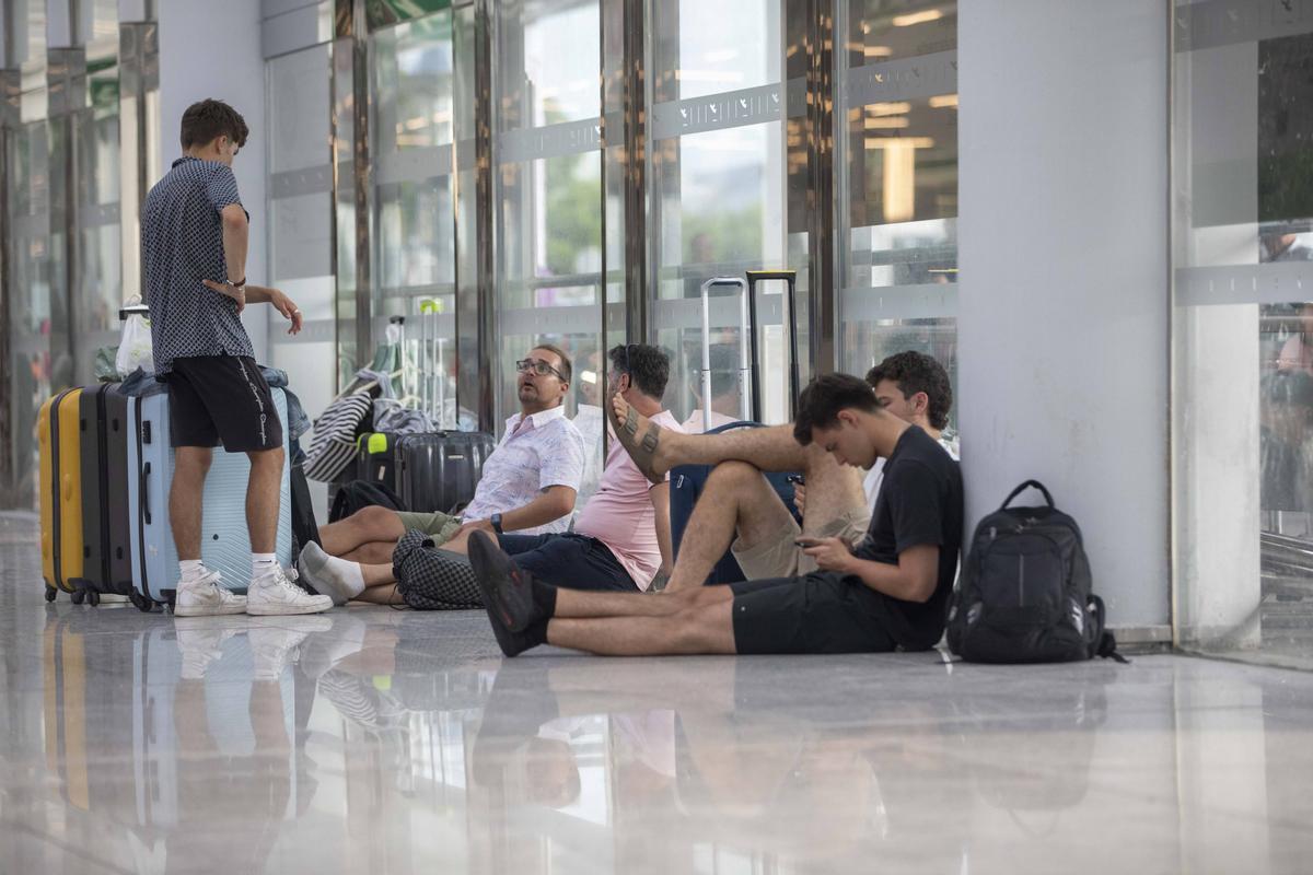 Los pasajeros esperan sentados en el aeropuerto