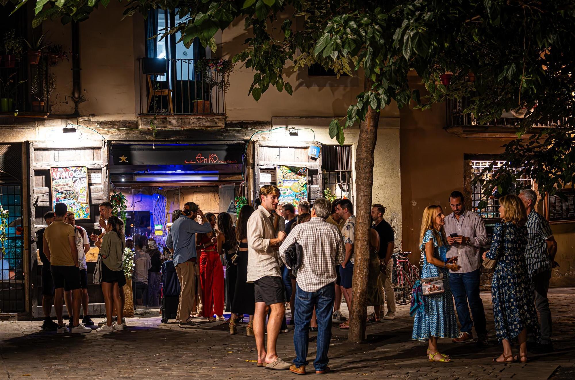 Clientes de un bar de las inmediaciones del paseo del Born beben y charlan en la calle, en Barcelona.