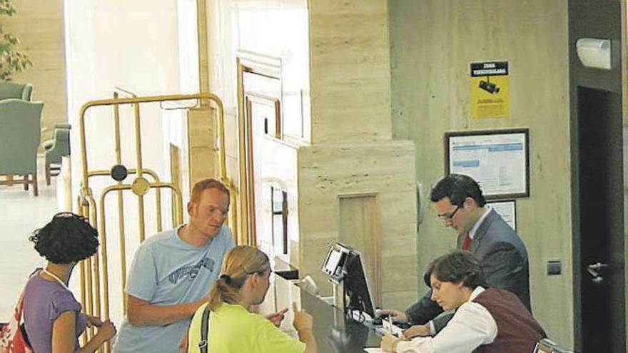 Clientes de un hotel dialogando con el personal.