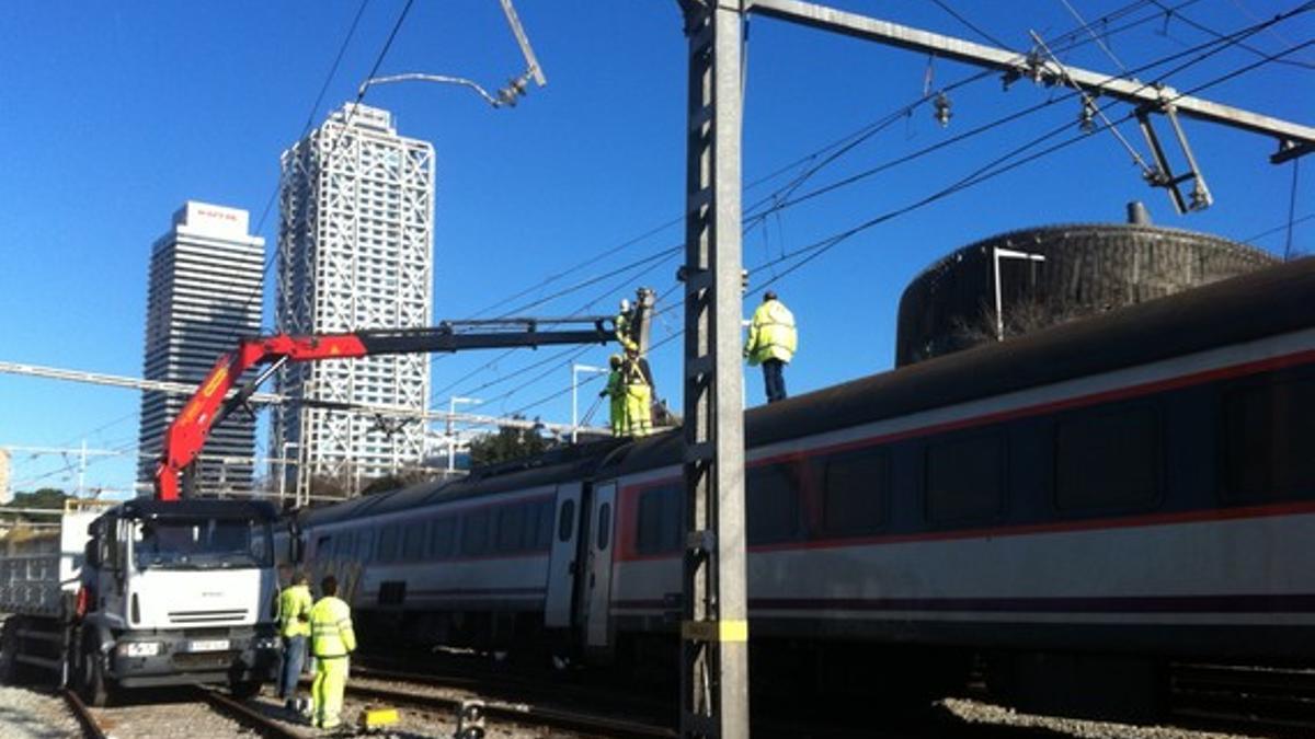 Operarios trabajan en el tren descarrilado, en la estación de França de Barcelona.