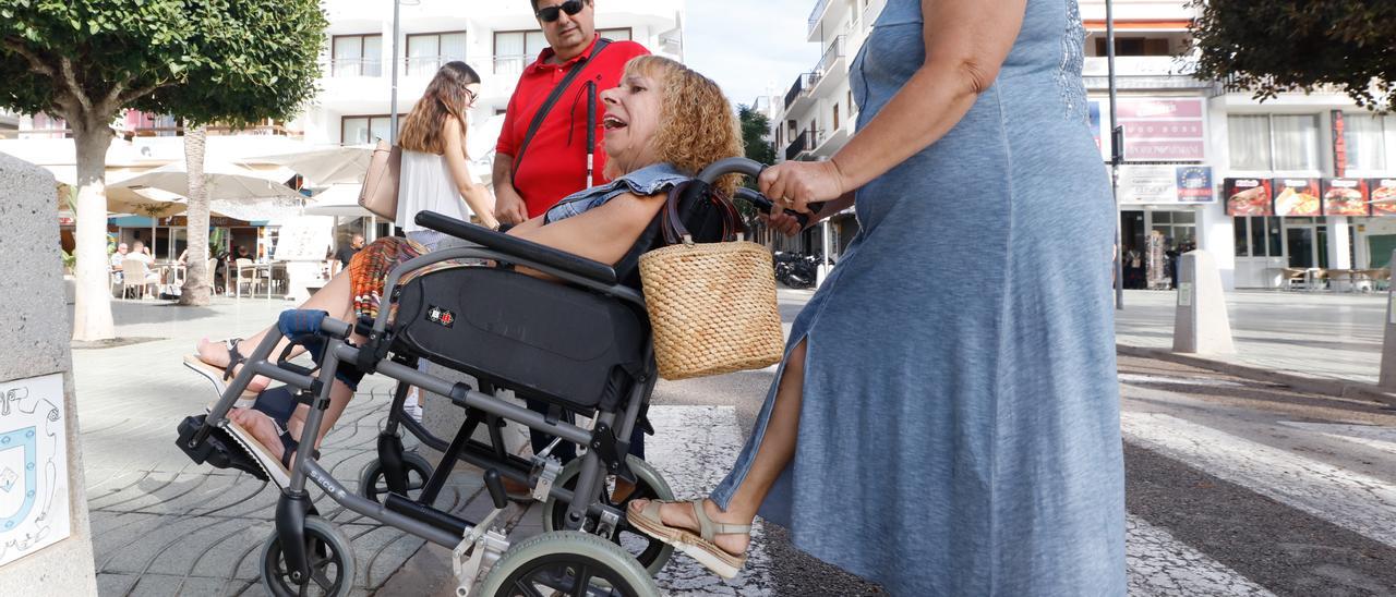 Una vecina de Sant Antoni se desplaza en silla de ruedas por el centro del pueblo.