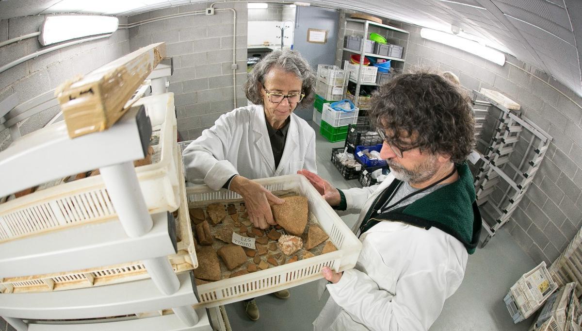 Montserrat Pugès y Emili Revilla, junto a pequeñas piezas de cerámica recientemente llegadas al Servei d'Arqueologia, lavadas pero pendientes de inventariar.