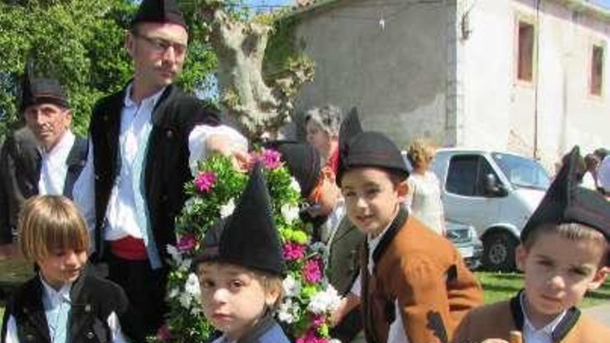 De izquierda a derecha, los niños llevando los ramos, Rubén del Cueto portando el pendón de la parroquia, y Francisco González y Estéfani Quesada, con su hijo Manuel.