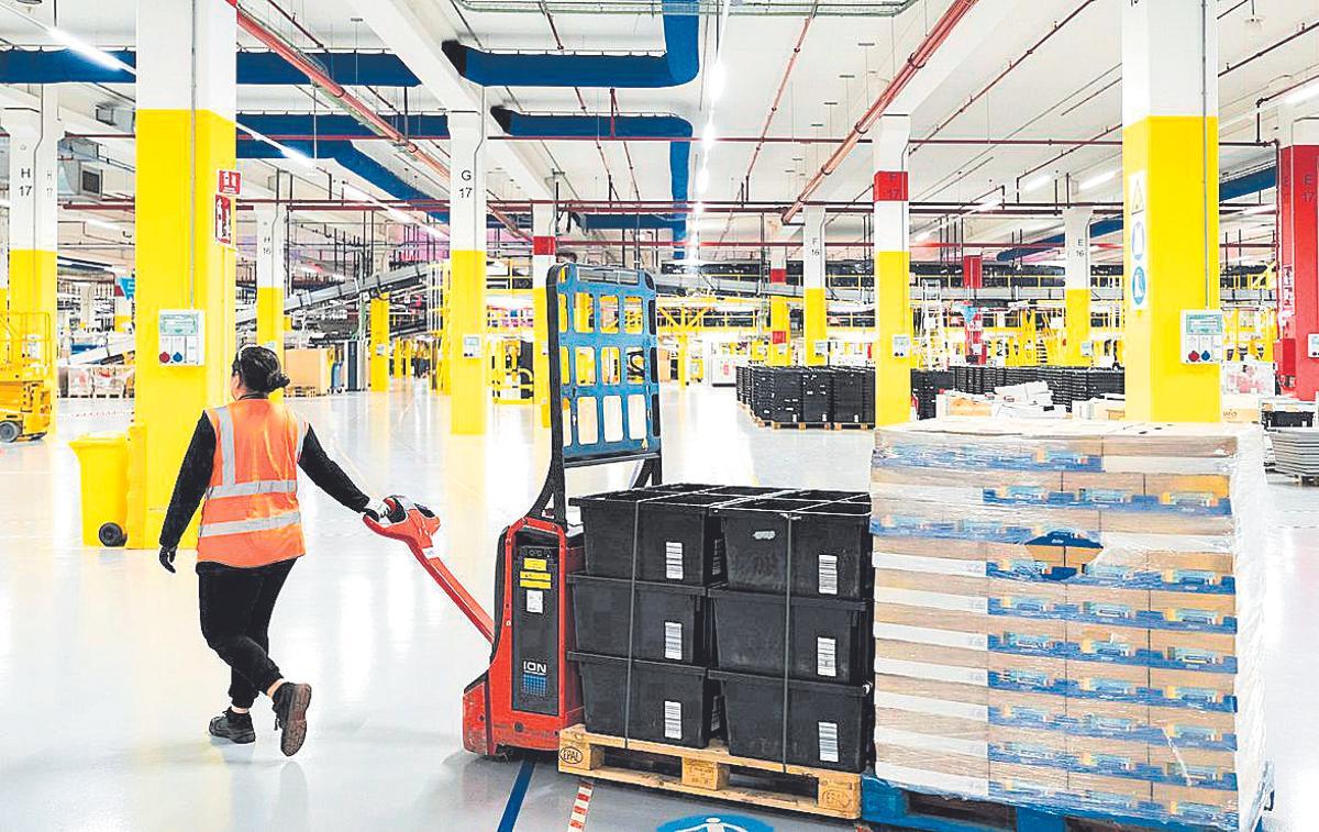 Una treballadora transporta productes al centre d’Amazon.