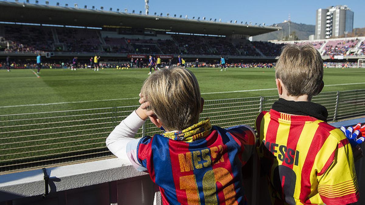 Dos niños con camisetas de Messi siguen con tristeza la sesión del Barça en el Mini por la ausencia de su ídolo