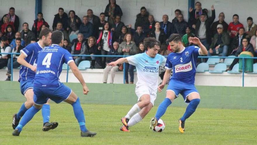 El delantero de la UD Ourense Isi, rodeado el sábado en O Lourambal de tres defensores del Porriño. // Yedra Seara