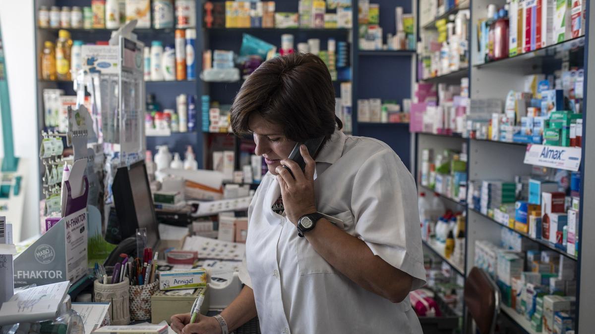Miriam García, farmacéutica, atiende una llamada en la farmacia