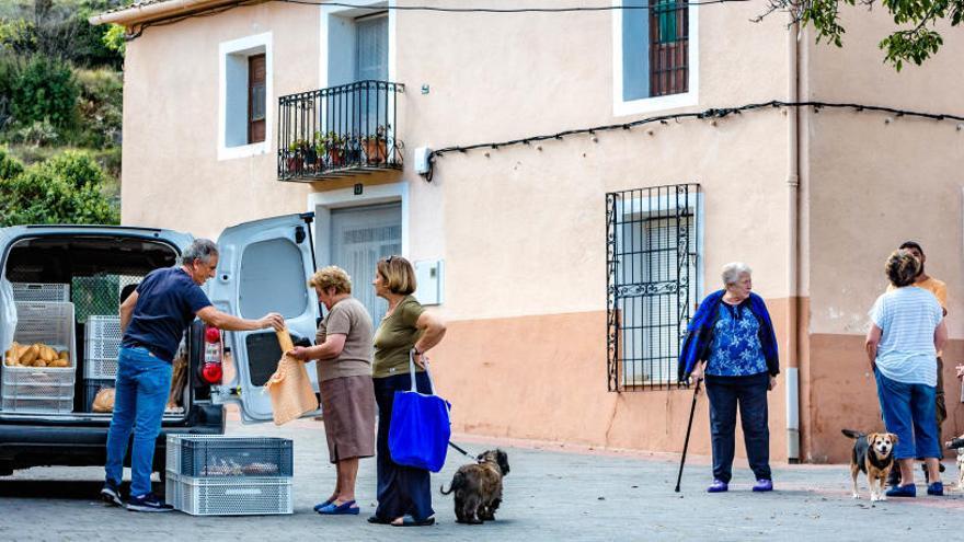 Vecinos de Confrides, en el interior de la Marina Baixa, comprando el pan a un vendedor ambulante.