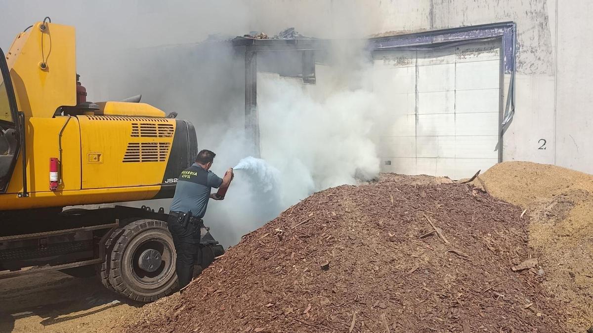 Una patrulla de la Guardia Civil sofoca un incendio en una nave industrial de Espiel.
