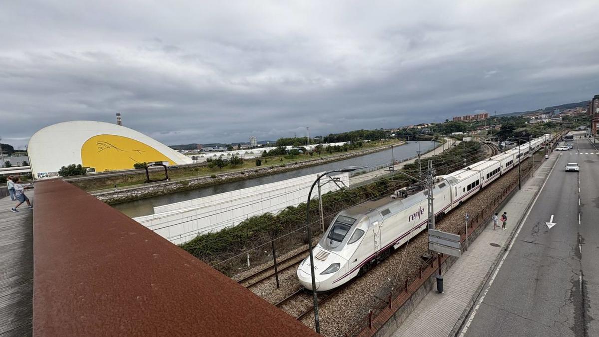 El Alvia a Madrid, con el Centro Niemeyer a la izquierda, desde la pasarela de la Grapa. | MIKI LÓPEZ