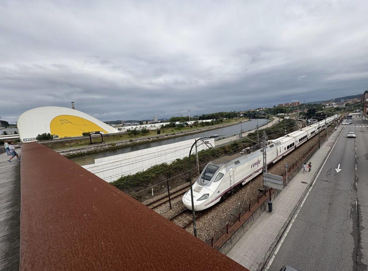 El Alvia a Madrid, con el Centro Niemeyer a la izquierda, desde la pasarela de la Grapa. | MIKI LÓPEZ