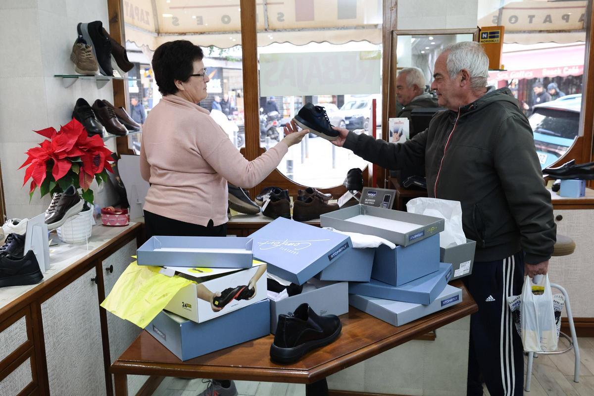 Maria Torres le muestra unos zapatos a un cliente .