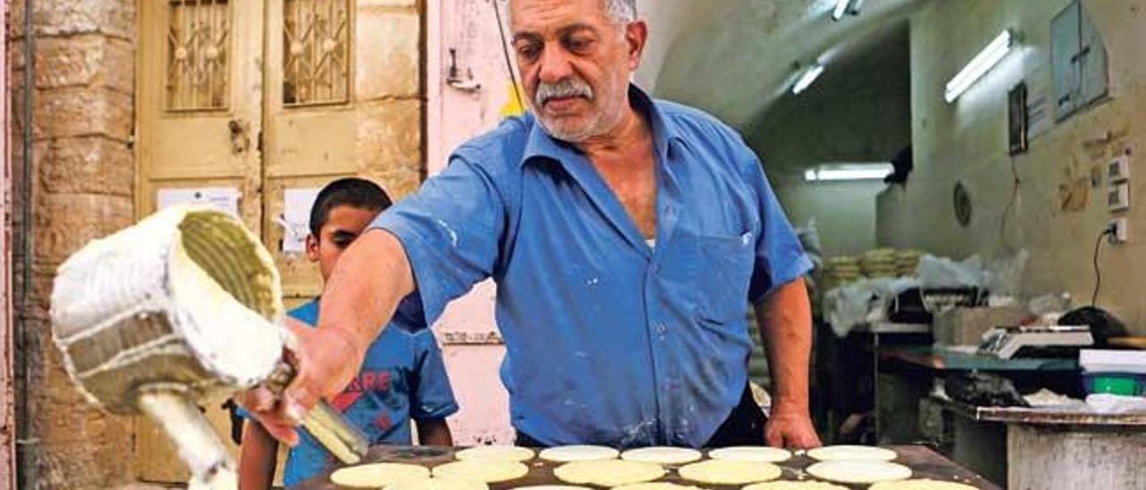 Un vendedor palestino prepara el dulce típico del Ramadán.