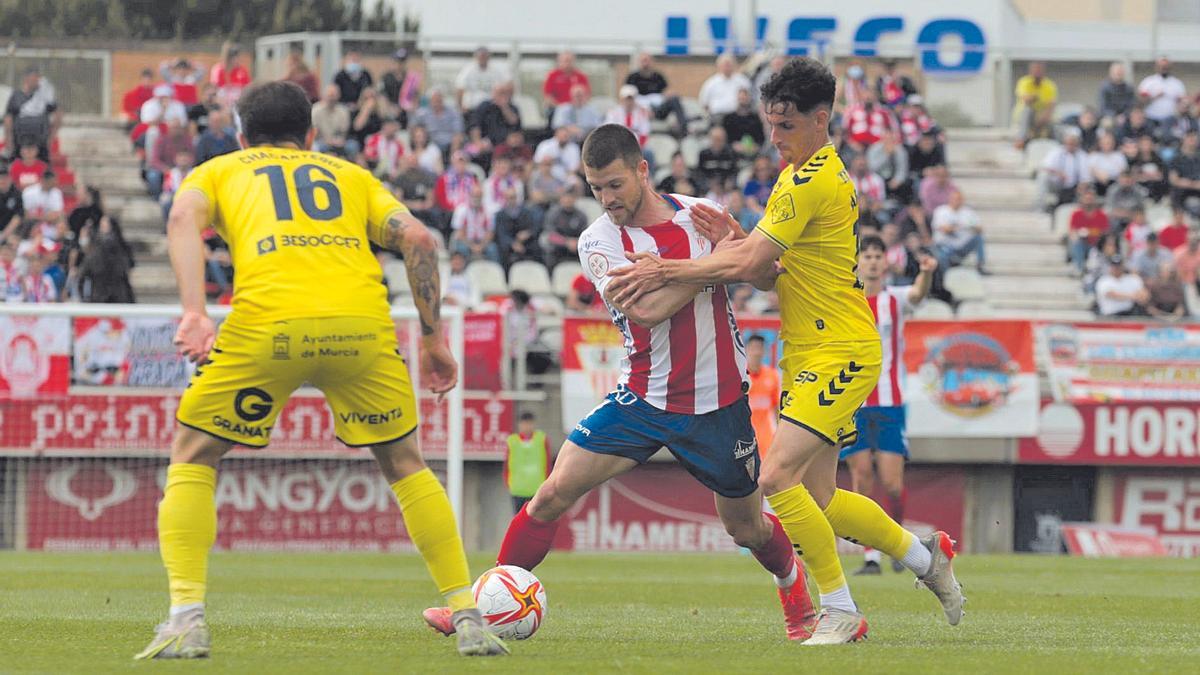 El centrocampista Armando Corbalán, del UCAM Murcia CF, tratando de luchar por un balón durante el encuentro.